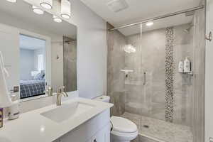 Ensuite bathroom featuring vanity and a shower stall