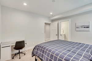 Bedroom featuring an office area, light carpet, and recessed lighting