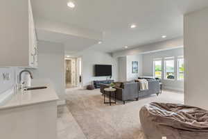 Living area featuring light colored carpet and recessed lighting