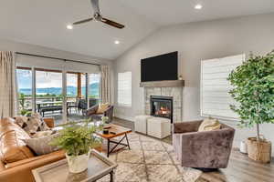Living room featuring ceiling fan, light wood-style floors, a stone fireplace, and recessed lighting