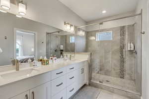 Full bathroom with connected bathroom, double vanity, and a stall shower