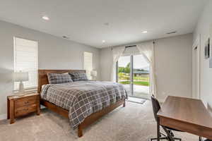 Carpeted bedroom featuring access to exterior, recessed lighting, and a desk