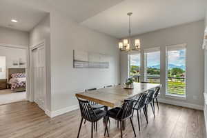 Dining room featuring a mountain view, light wood-style floors, and hanging lights