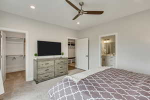 Bedroom featuring light carpet, a walk in closet, a ceiling fan, recessed lighting, and connected bathroom