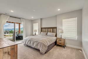 Bedroom featuring a mountain view, access to exterior, light colored carpet, and recessed lighting