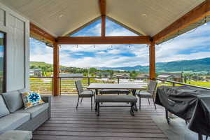 Deck featuring a residential view, an outdoor living / dining area, and a mountain view