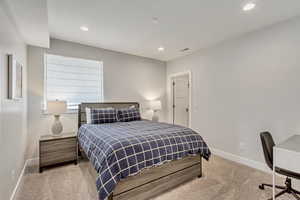 Bedroom featuring light carpet, an office area, and recessed lighting