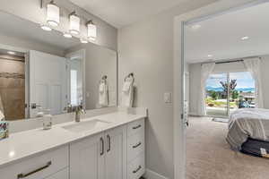 Bathroom featuring vanity, recessed lighting, connected bathroom, and light carpet