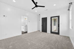 Unfurnished bedroom with dark carpet, a ceiling fan, recessed lighting, and ensuite bath