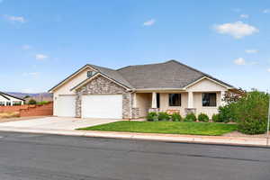 View of front of house featuring a garage, covered porch, a front yard, concrete driveway, and a tiled roof