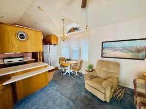 Kitchen featuring light countertops, white appliances, a ceiling fan, wood finish cabinets, and hanging lights