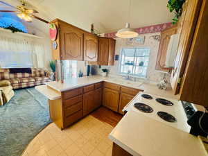 Kitchen with wood finish cabinets, a textured ceiling, light countertops, open floor plan, and ceiling fan