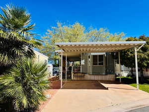 View of front of property with driveway and a carport