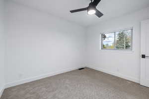 Carpeted spare room with baseboards and a ceiling fan