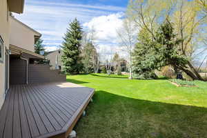 View of green lawn featuring a deck