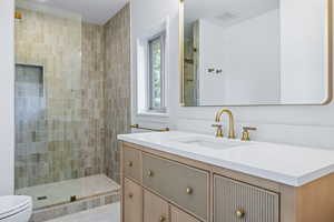 Full bath with vanity and a tile shower