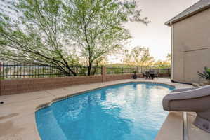 View of swimming pool featuring patio surround, a fenced backyard, and a water slide