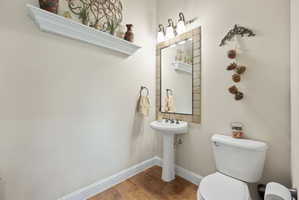 Half bathroom featuring baseboards and wood finished floors