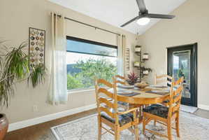Dining space featuring hardwood / wood-style floors, lofted ceiling, and a ceiling fan