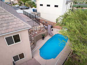 View of swimming pool with a water slide and patio surround