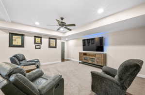 Living room with carpet, ceiling fan, recessed lighting, and a raised ceiling
