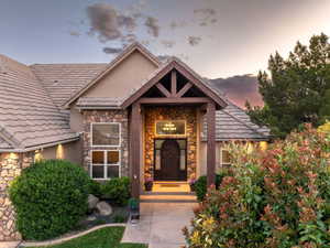 View of exterior entry with stone siding and stucco siding