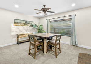 Dining space with light carpet, ceiling fan, and recessed lighting