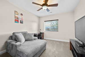 Sitting room featuring light carpet and a ceiling fan