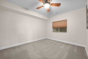 Empty room featuring ceiling fan and carpet