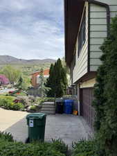 View of property exterior featuring a patio, a mountain view, and a garage
