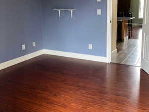 Empty room with a textured ceiling, a ceiling fan, and dark wood-style floors