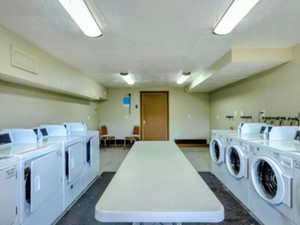 Community laundry featuring washing machine and dryer and a textured ceiling