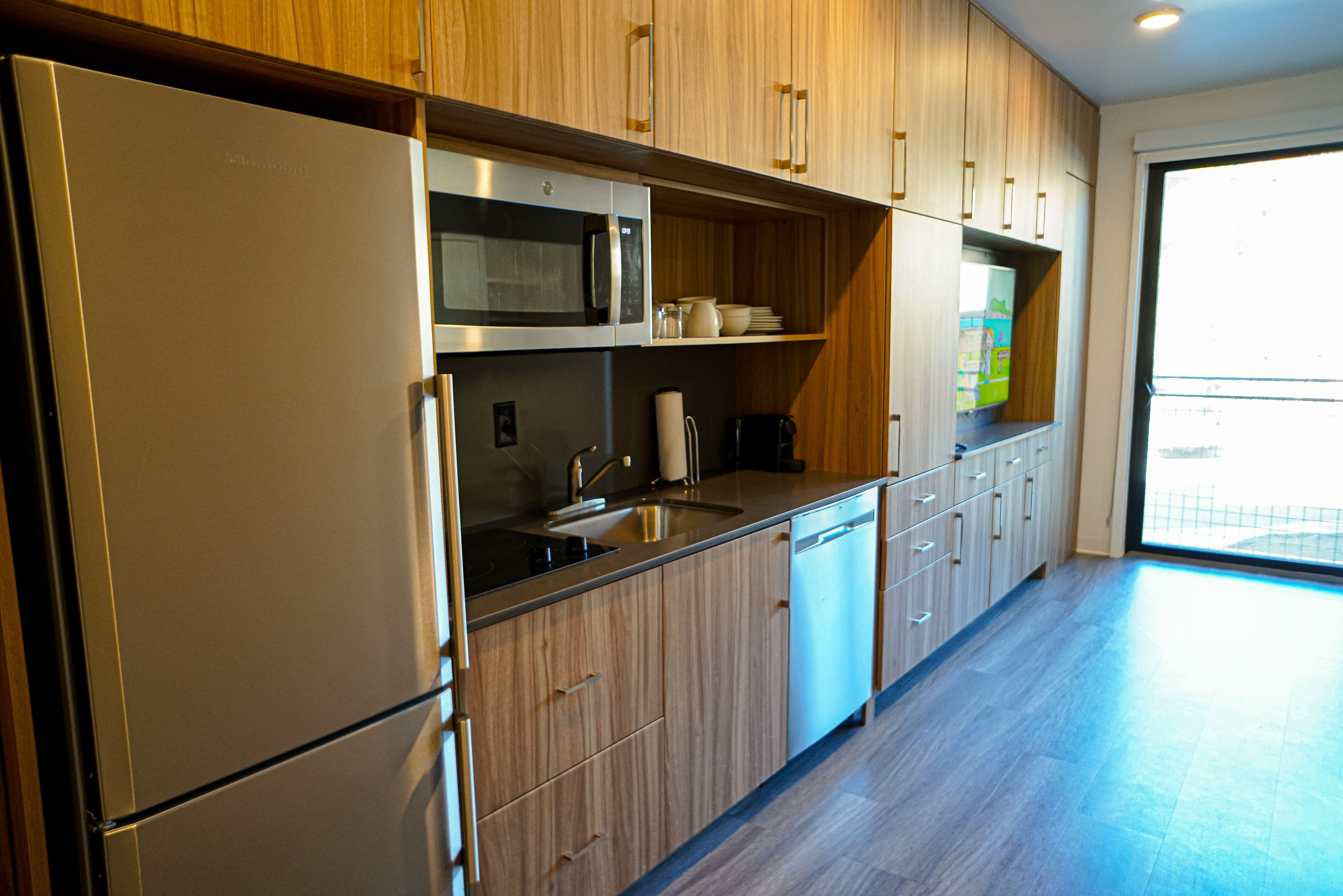 Kitchen with stainless steel appliances, dark wood finished floors, open shelves, modern cabinets, and light wood finish cabinets
