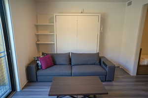 Living area with dark wood-type flooring and baseboards