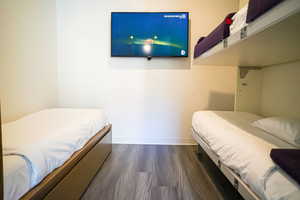 Bedroom with dark wood-style floors and baseboards