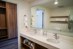 Full bathroom featuring a towel warmer and double vanity