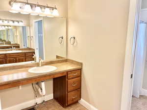 Full bath featuring vanity and light tile patterned floors