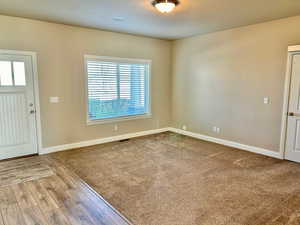 Foyer with light wood-type flooring and light colored carpet