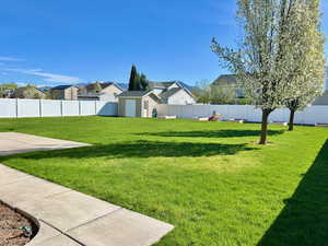 Fenced backyard featuring an outbuilding and a residential view