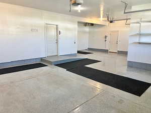 Garage featuring a garage door opener and baseboards