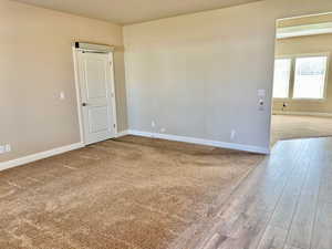 Spare room featuring light colored carpet and light wood-type flooring