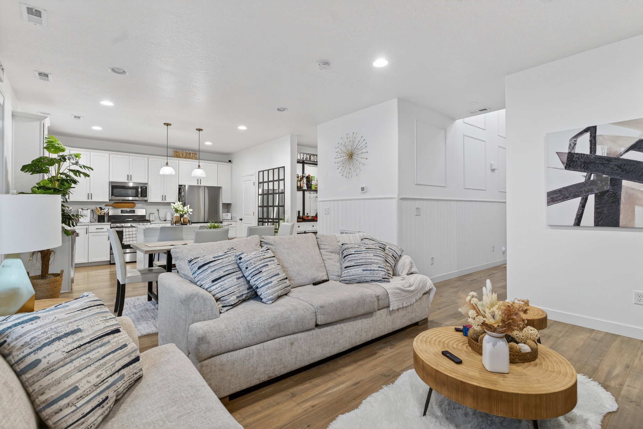 Living room featuring light wood-style floors, a wainscoted wall, and recessed lighting