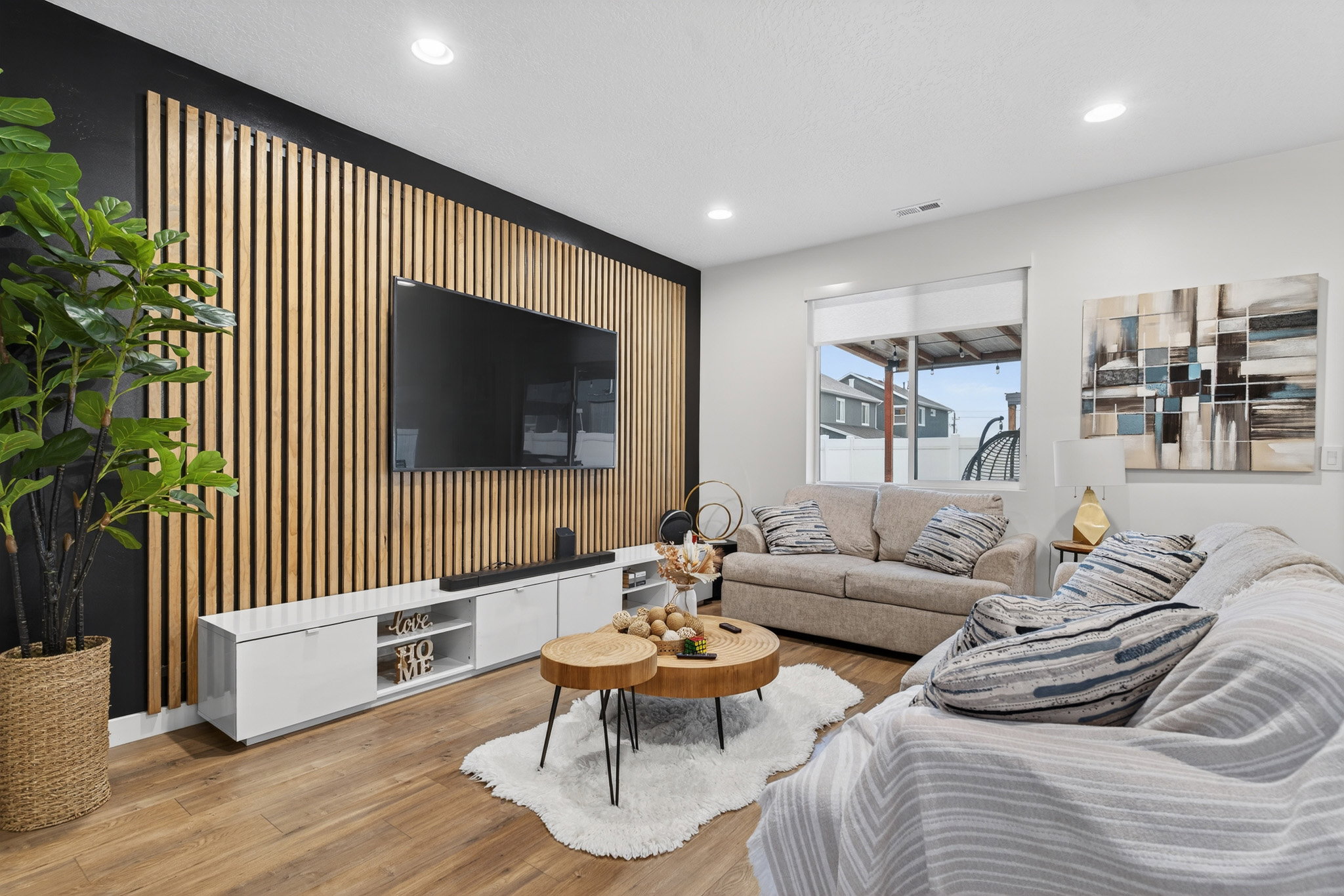 Living area with an accent wall, wood finished floors, and recessed lighting