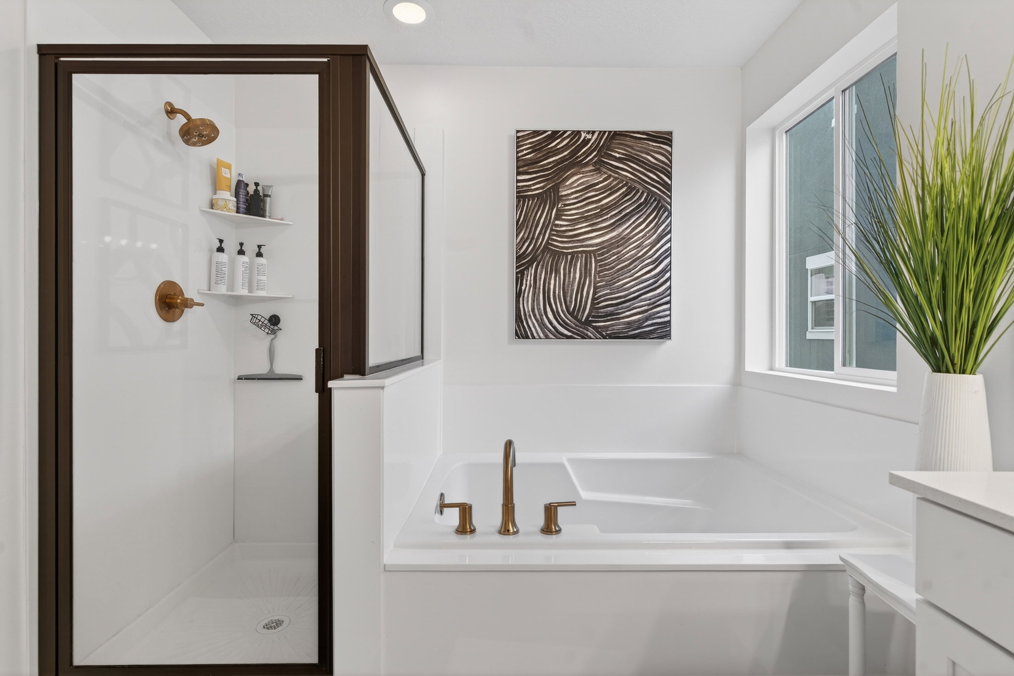 Bathroom featuring a garden tub, a shower stall, and vanity