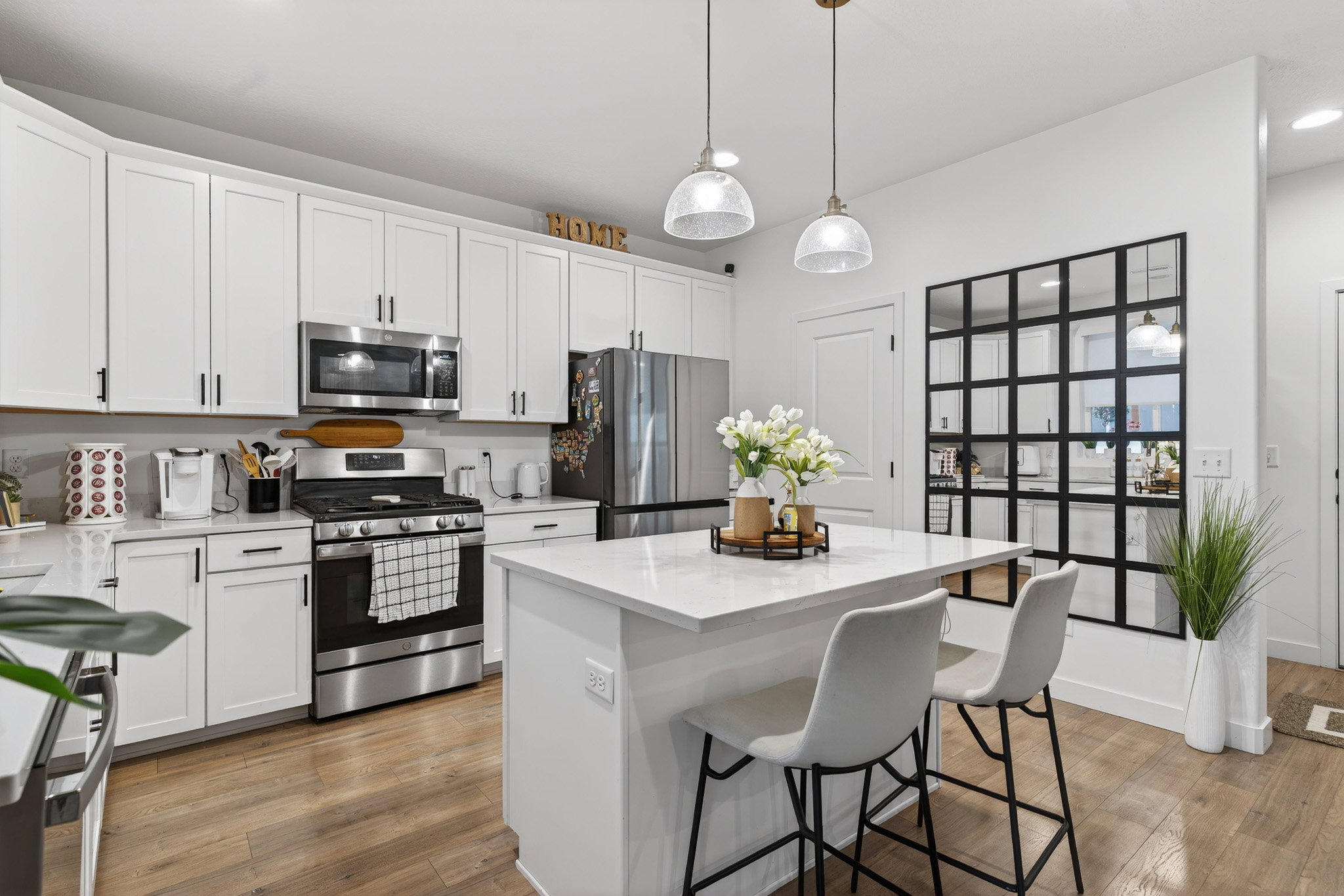 Kitchen with white cabinetry, stainless steel appliances, a kitchen breakfast bar, and a kitchen island