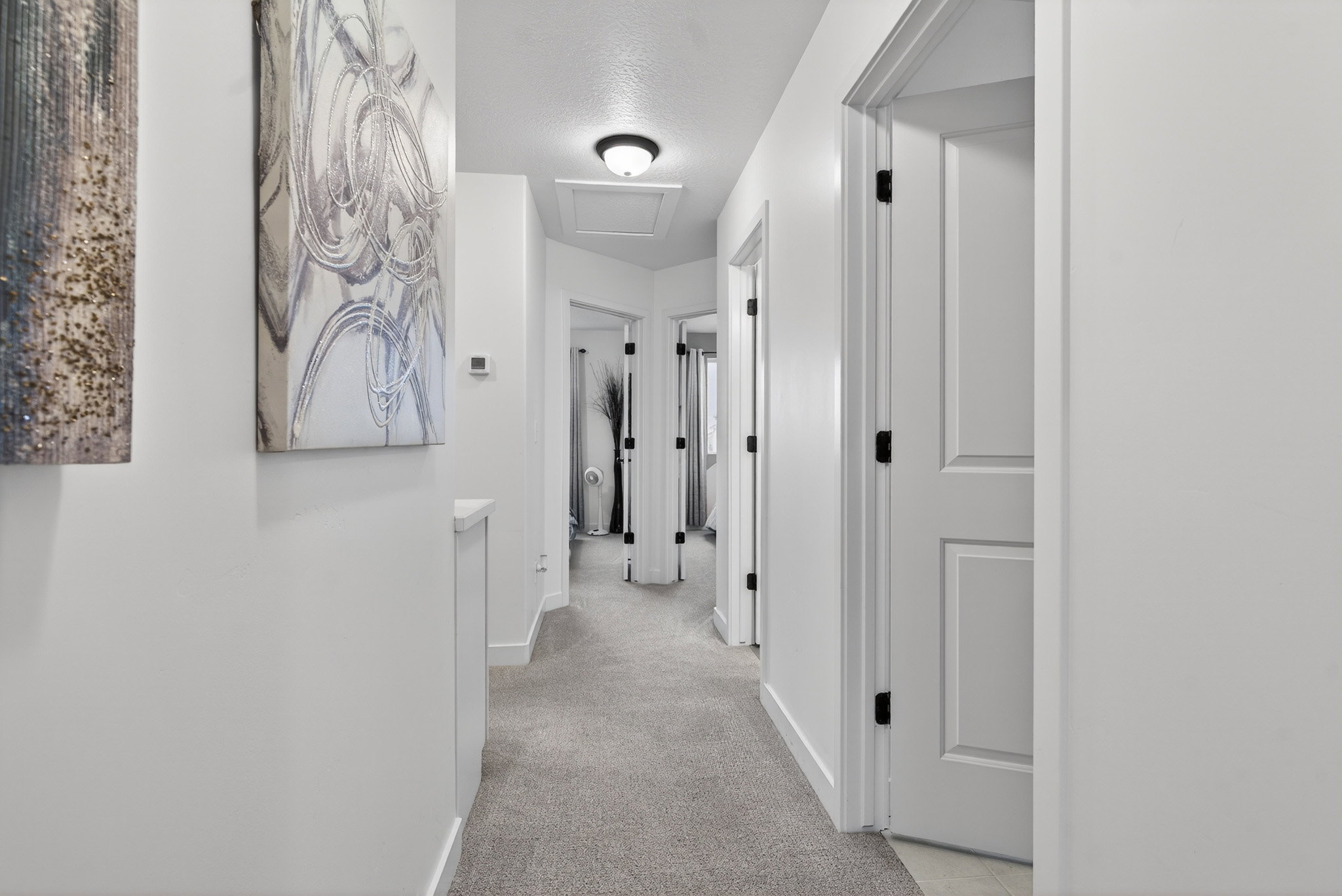 Corridor featuring attic access and light carpet