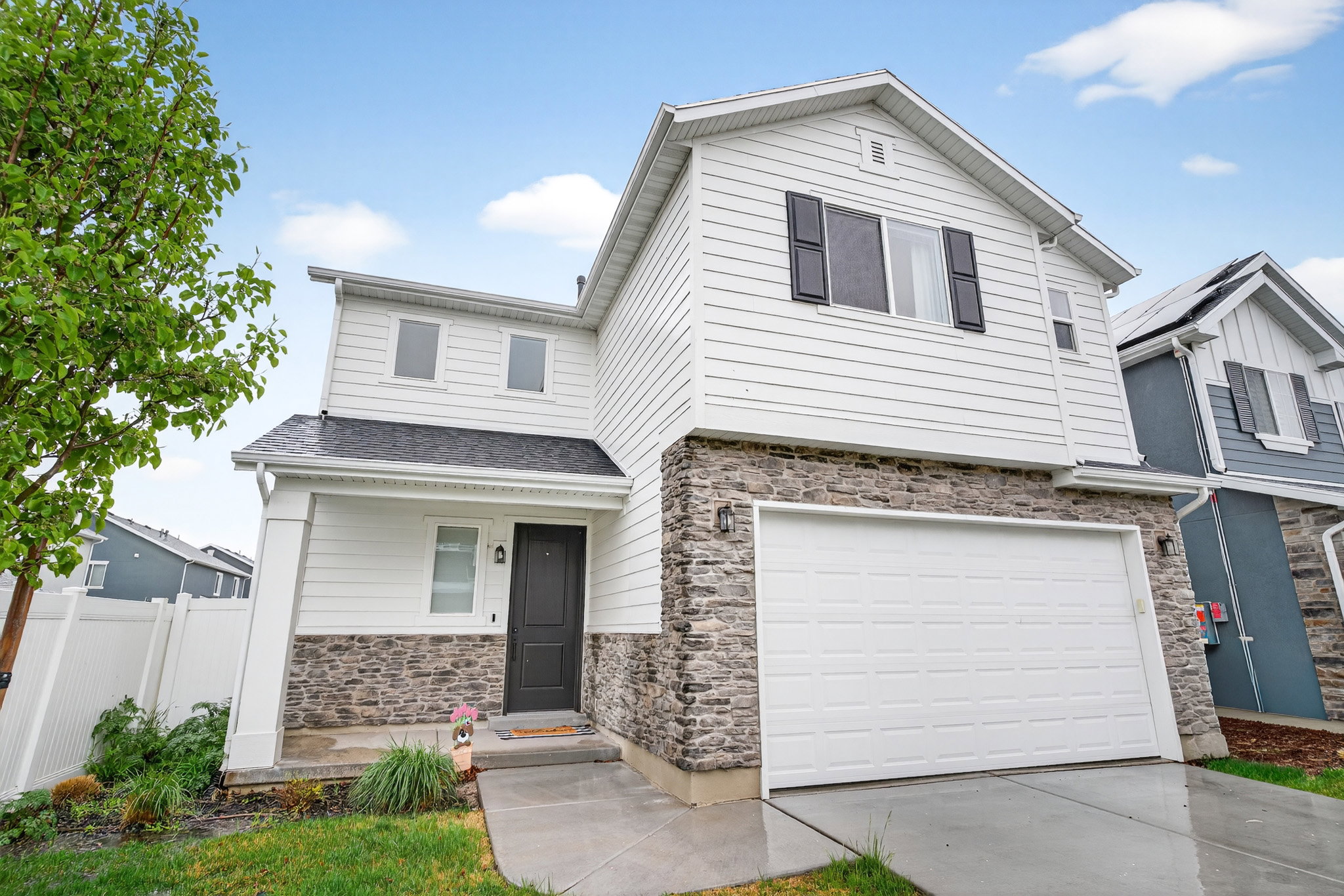 Craftsman house featuring stone siding, an attached garage, and driveway