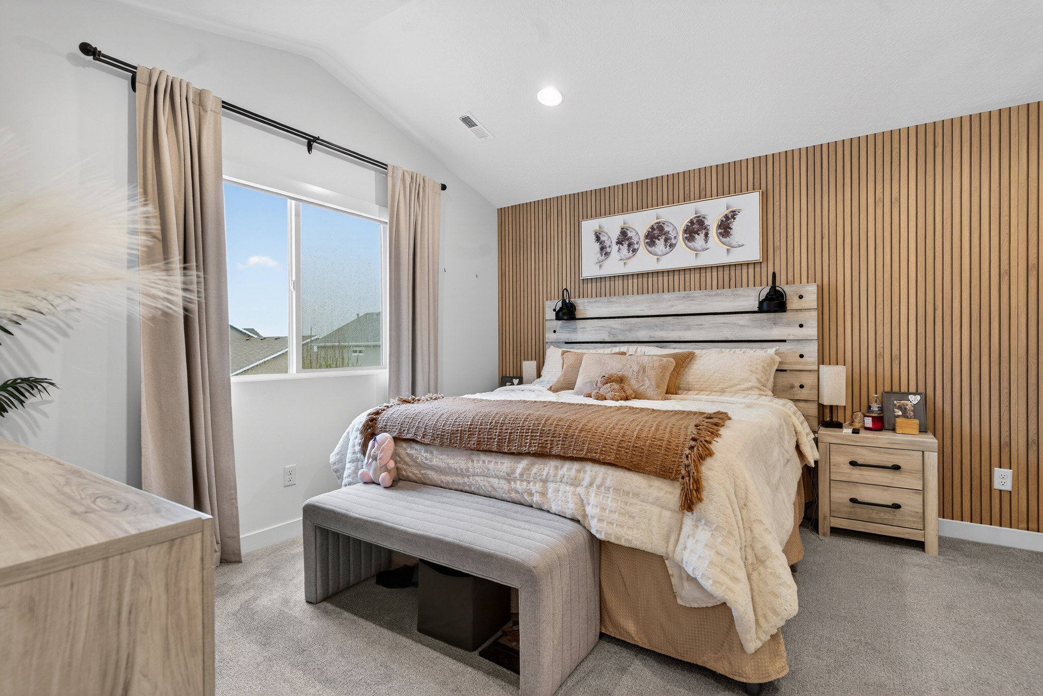 Bedroom featuring wooden walls, vaulted ceiling, recessed lighting, an accent wall, and light carpet