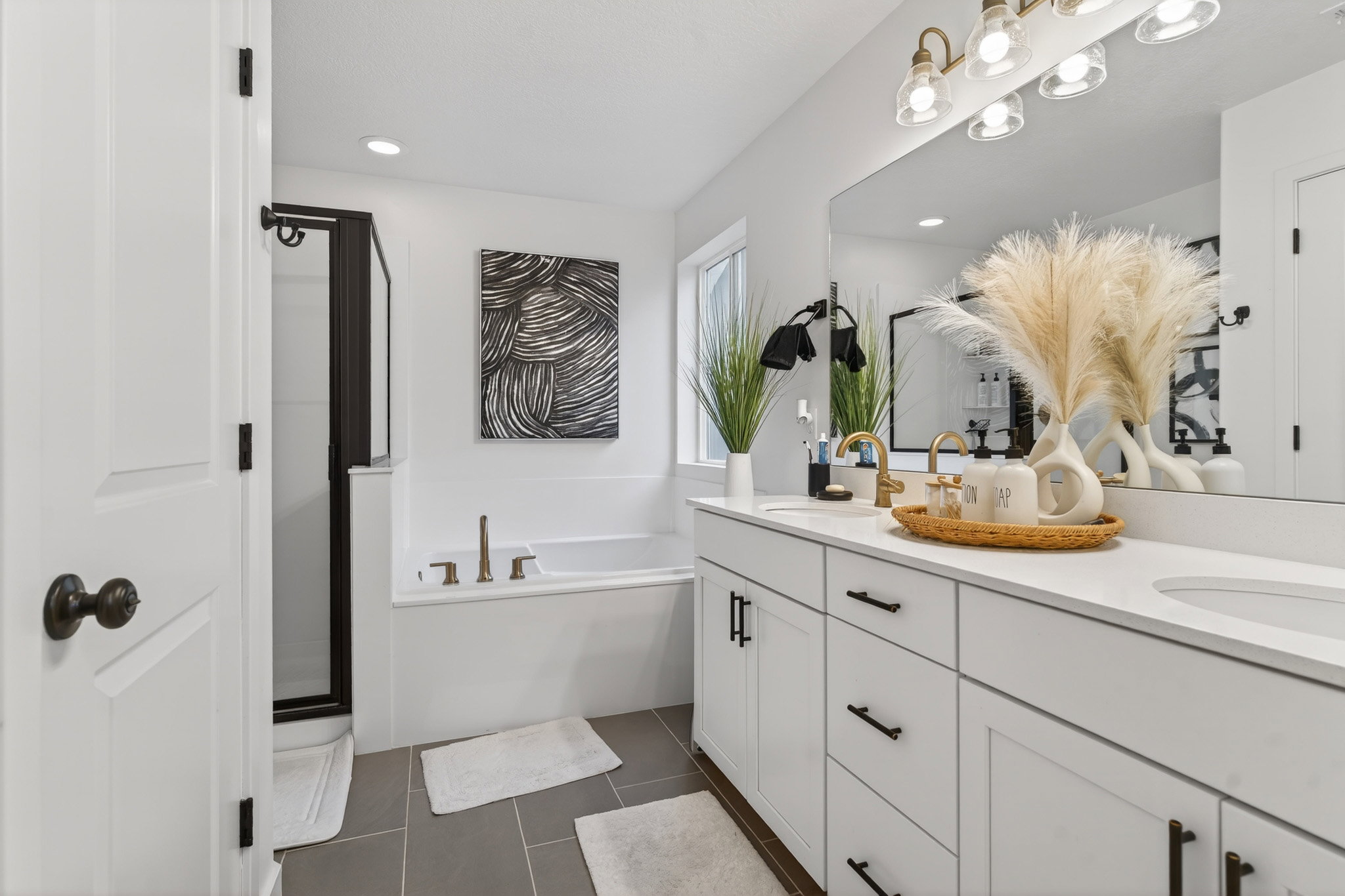 Bathroom featuring double vanity, a garden tub, a shower stall, dark tile patterned flooring, and recessed lighting