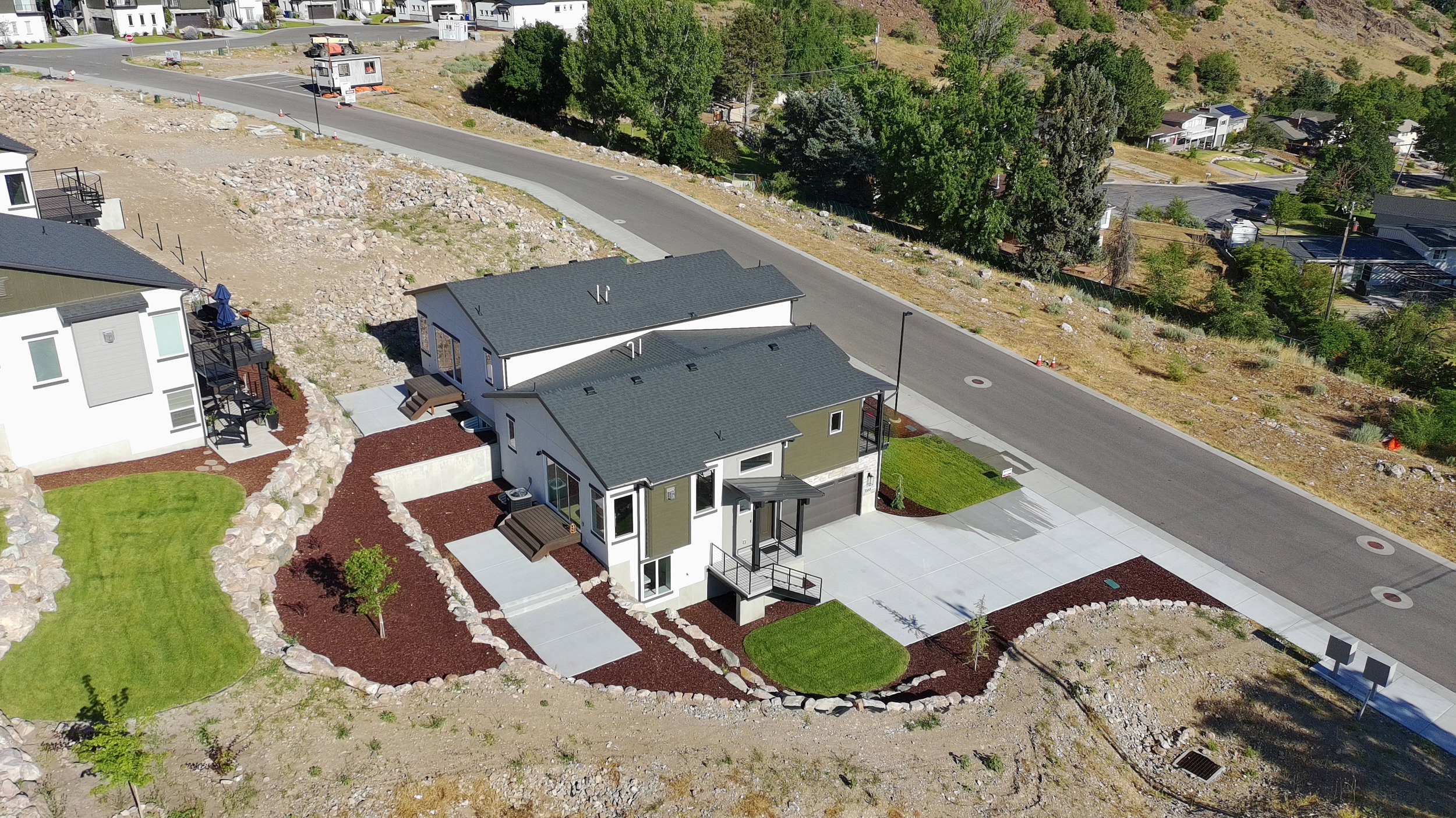 Modern two-story residence with a multi-tone exterior, featuring a two-car garage and a paved driveway